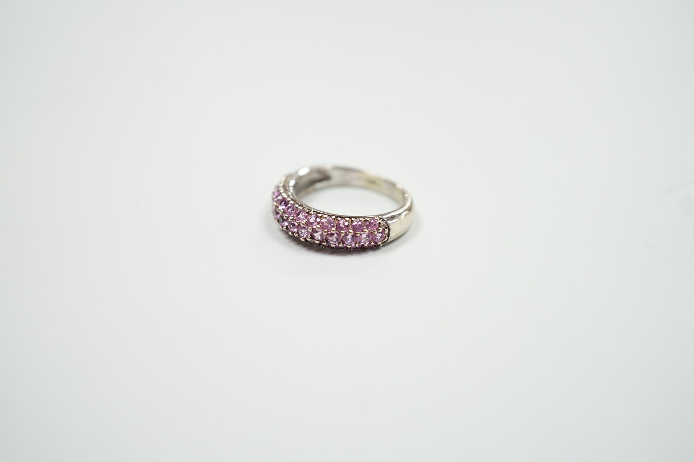 A modern 18ct white gold and pink stone cluster set half hoop ring, size J, gross weight 4.2 grams.